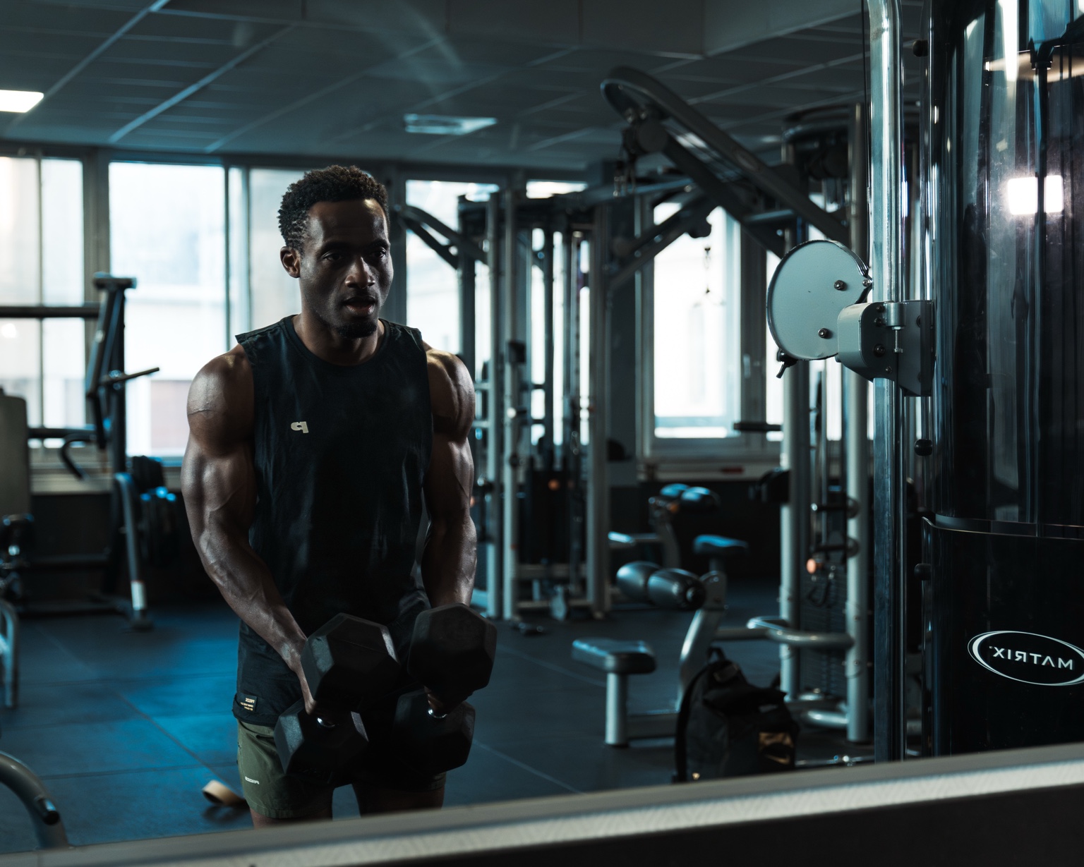Basile s’entraîne avec des haltères dans une salle de musculation
